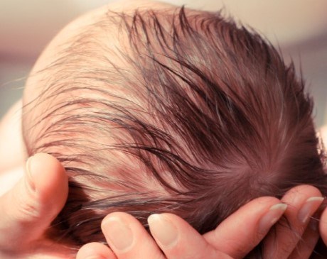 Woman holding newborn infant in her arms. 